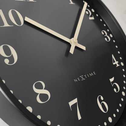 NeXtime Dickens wall clock, 30cm black and white plastic design, silent mechanism, detailed close-up image.