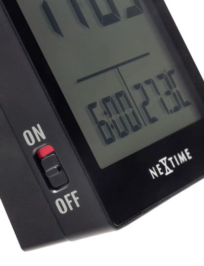 Close-up of NeXtime digital table alarm clock showing time display and sleek black design.