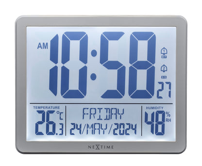 NeXtime digital alarm clock with weather station display, 17.3x14x2.7cm, ABS plastic, front view showing time and weather info.